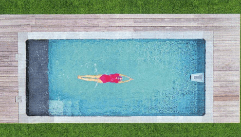 Schwimmerin in rotem Badeanzug schwimmt in einem Pool mit Gegenschwimmanlage, Aufnahme von oben